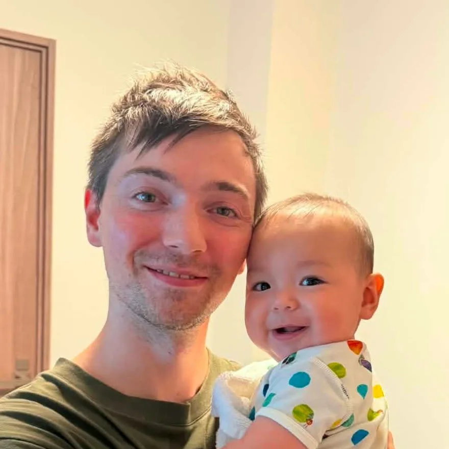 Chris at home, holding his baby son